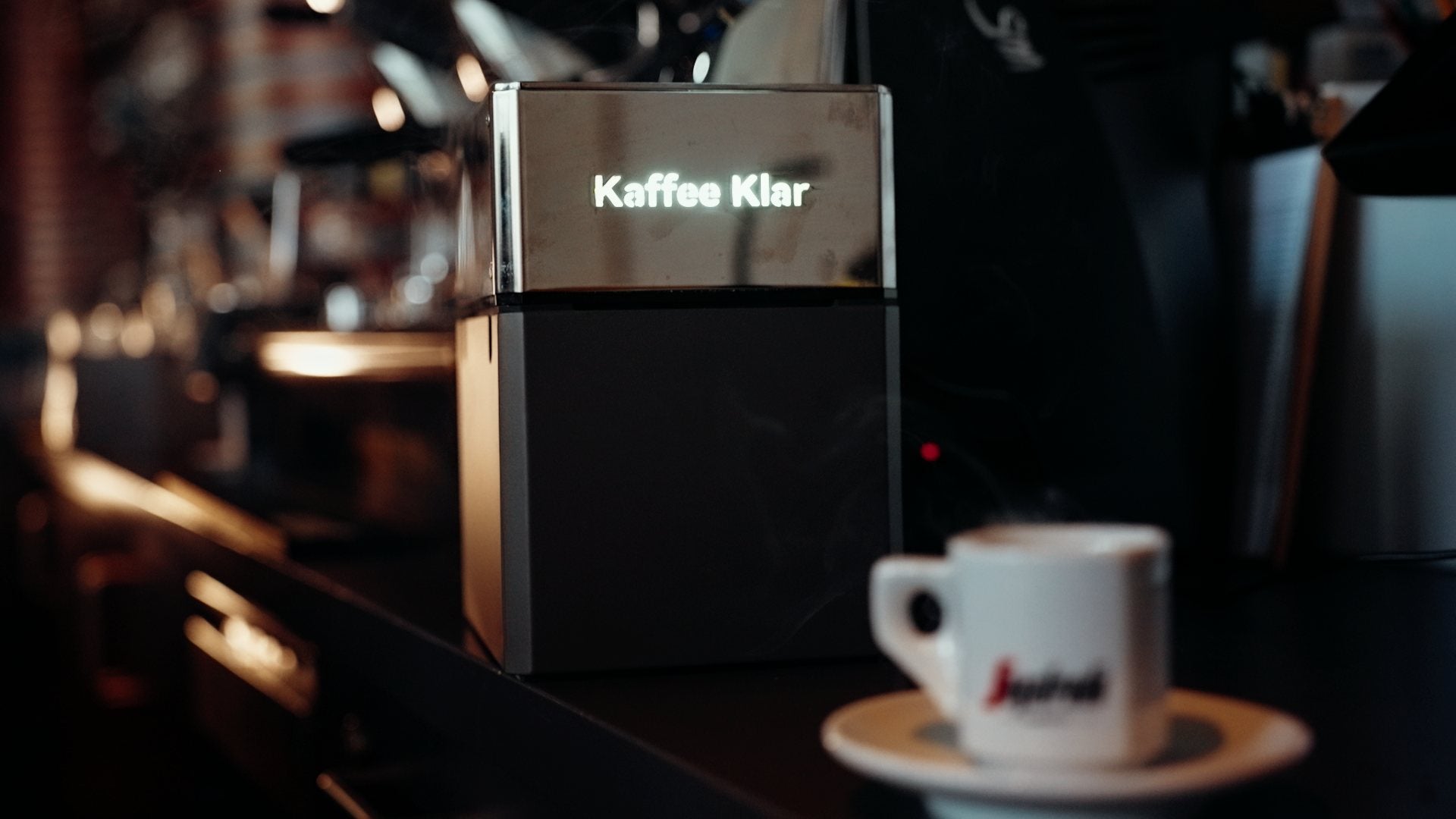 Kaffee Klar T1 beside an espresso machine